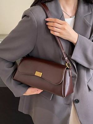 shoulder bag in dark brown featuring flap closure and structured fit
