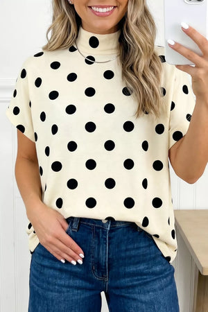 Cream polka dot mock neck short sleeve top with blue denim jeans