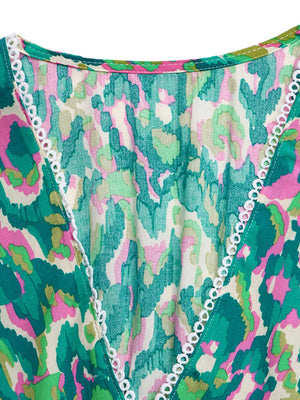 Vibrant V-neck maxi dress with abstract print and white trim detail.
