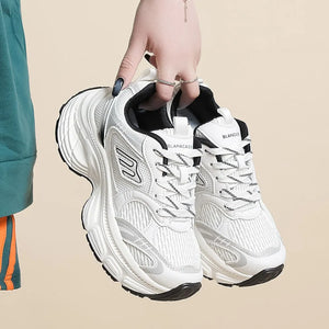 White chunky retro runner sneakers with black accents and a thick sole.