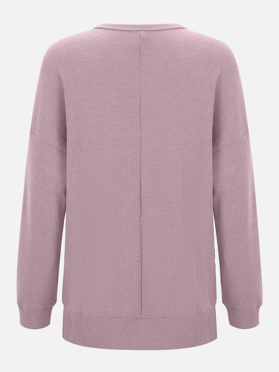Dusty pink waffle knit crewneck top with relaxed fit and long sleeves.