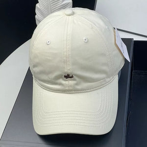 Cream white cotton baseball cap with embroidered detail and ventilation eyelets
