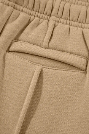 Tan sweatpants with elastic waistband and seam detail pocket