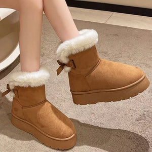 Caramel suede round-toe boots with white fur trim and bow detail.
