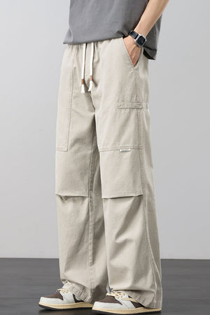 Beige cargo pants with adjustable drawstring and multiple pockets.