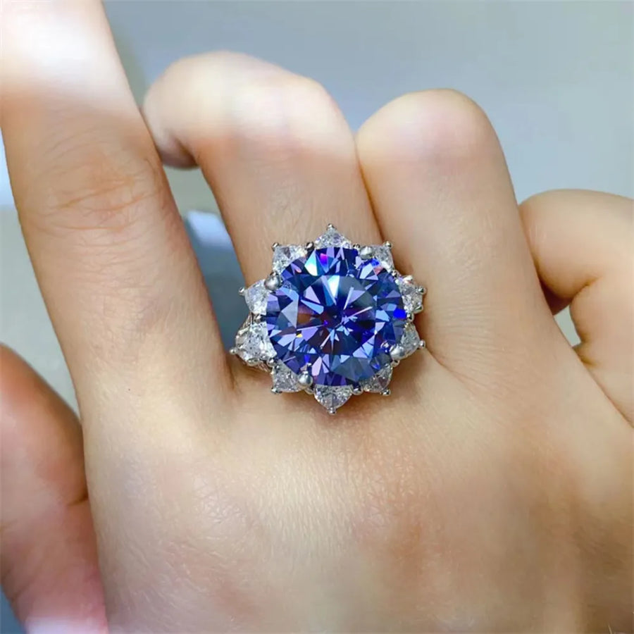 Dark blue moissanite cocktail ring in sterling silver with a starburst halo of smaller stones.