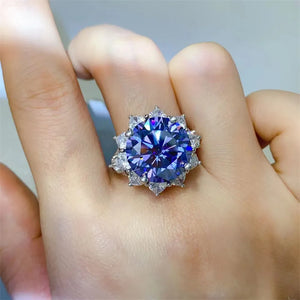 Dark blue moissanite cocktail ring in sterling silver with a starburst halo of smaller stones.