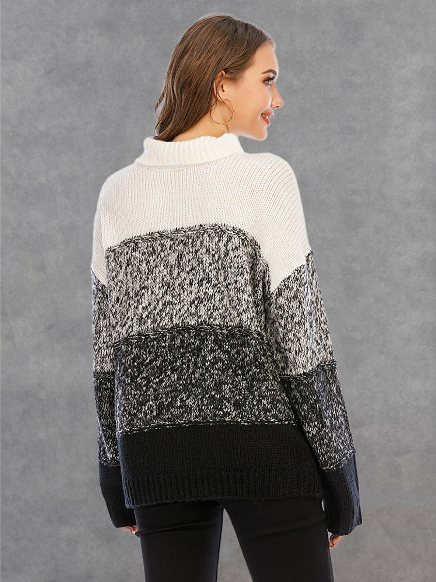 Colorblock turtleneck sweater with defined panels in white, black, and grey acrylic knit.