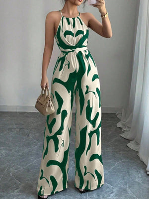 Elegant wide-leg jumpsuit in cream with abstract green print, halter neck, and draped bodice.
