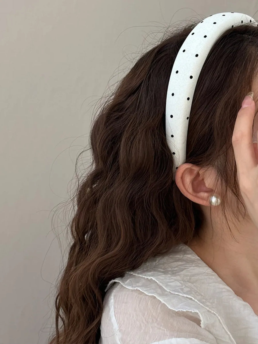 White padded headband with black polka dots and a handmade label detail.
