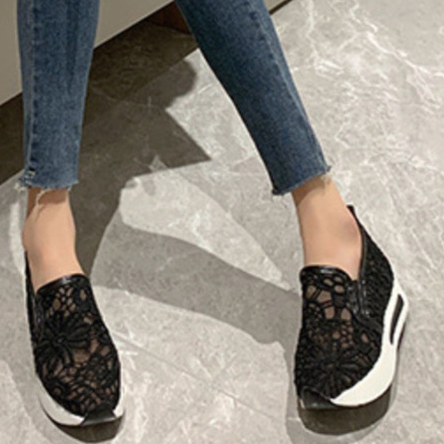 Black lace mesh slip-on flats with white soles.