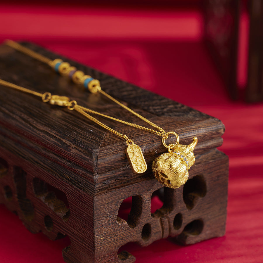 Gold necklace featuring gourd pendant and geometric
