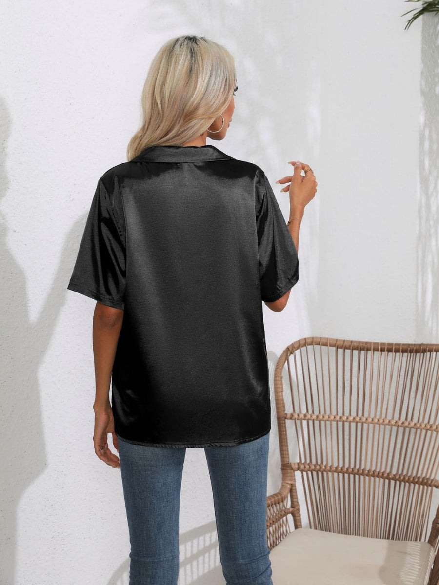 Black satin collared shirt with short sleeves, shown from the back.