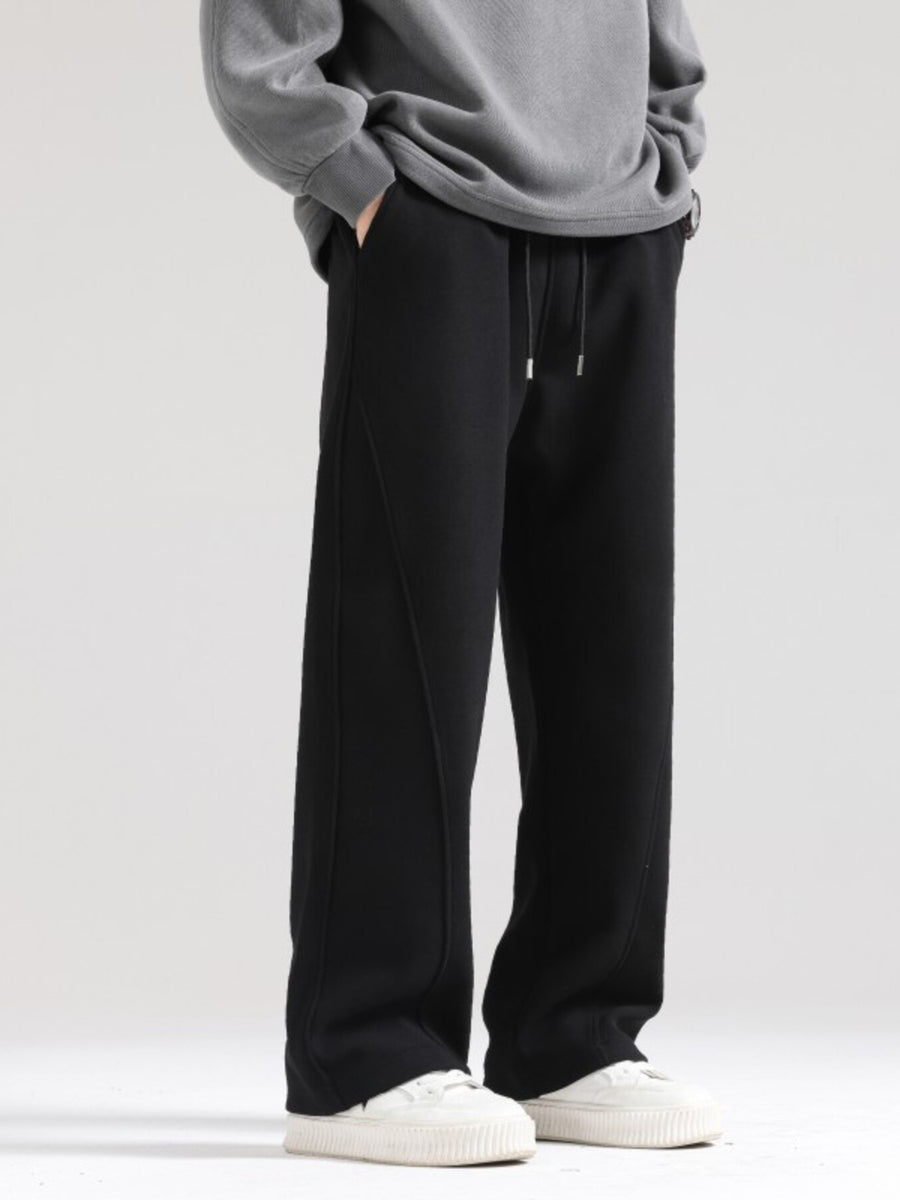 Men's black wide-leg sweatpants with drawstring waist and seam detail.