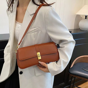 Brown rectangular crossbody bag with gold clasp and adjustable strap.