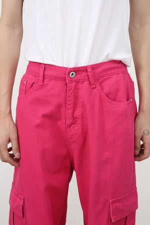 Electric pink baggy cargo pants with button fly and side pockets.