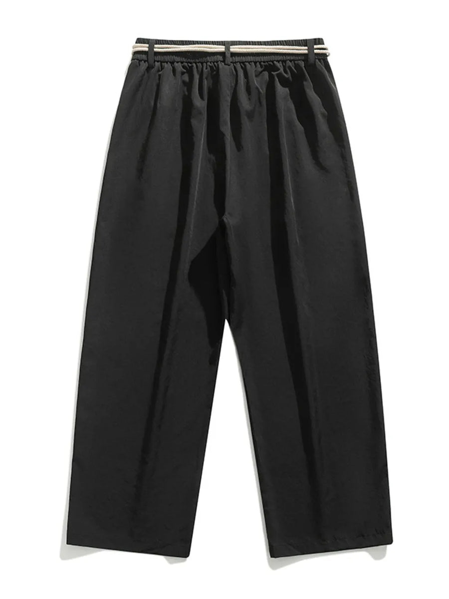 Black relaxed fit sweatpants with a belted waist and drawstring detail.