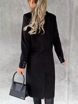 Black double-breasted longline trench coat with buttoned cuffs and a back vent.