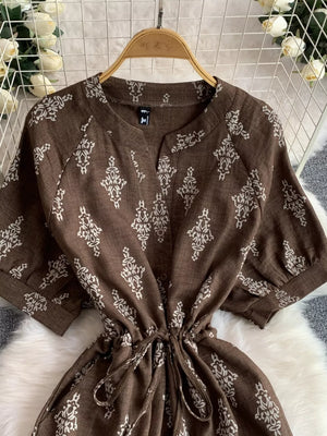 Brown patterned drawstring jumpsuit with short sleeves and V-neck.