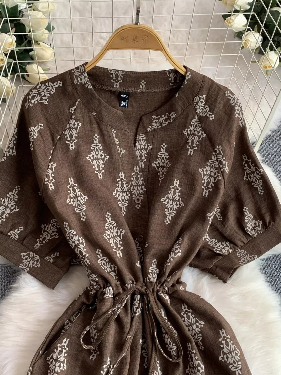 Brown patterned drawstring jumpsuit with short sleeves and V-neck.