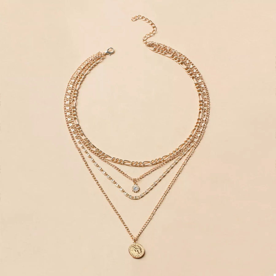 Gold layered coin pendant necklace with a clear stone accent