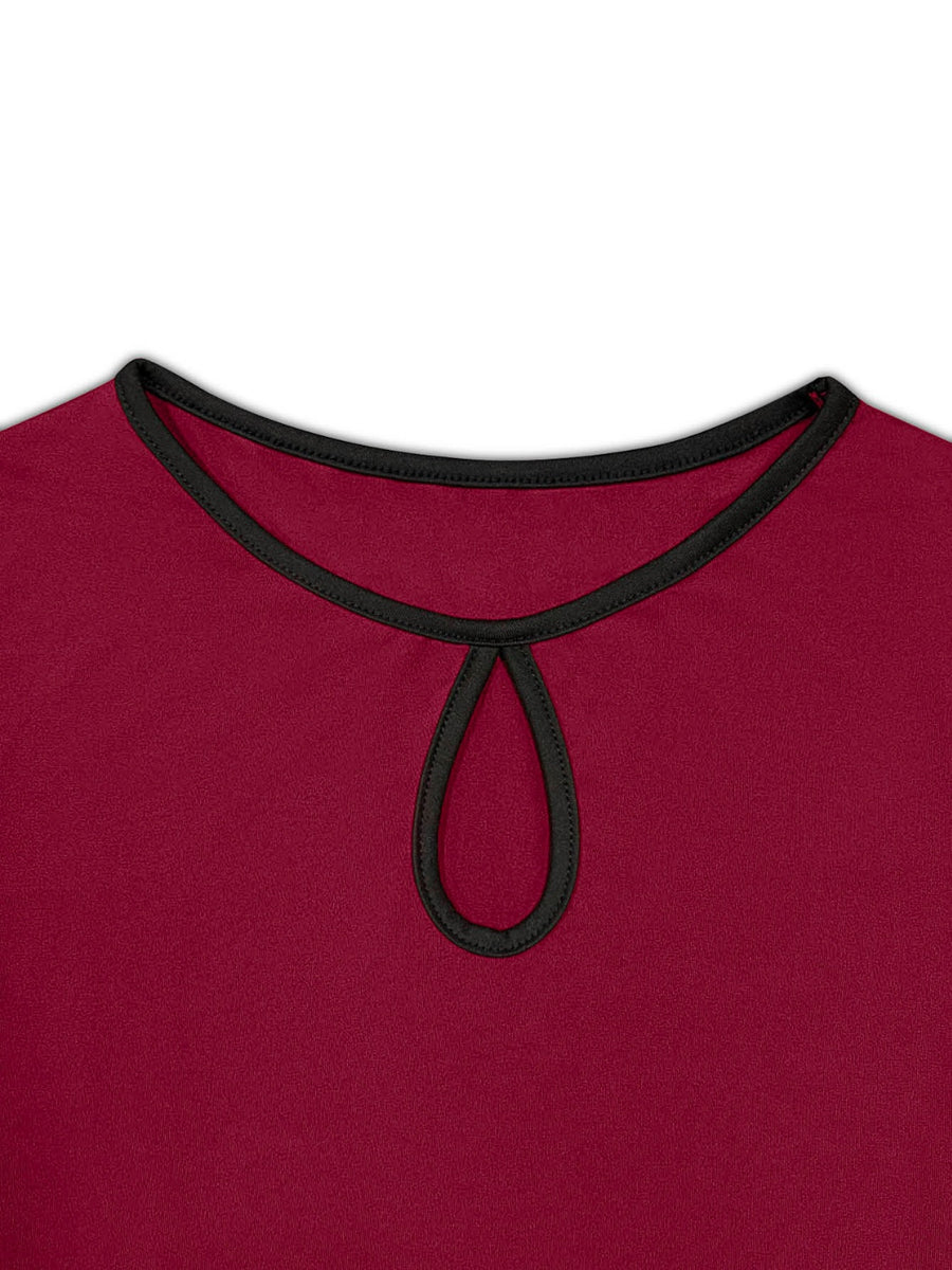 Burgundy peplum blouse with keyhole neckline and black trim.