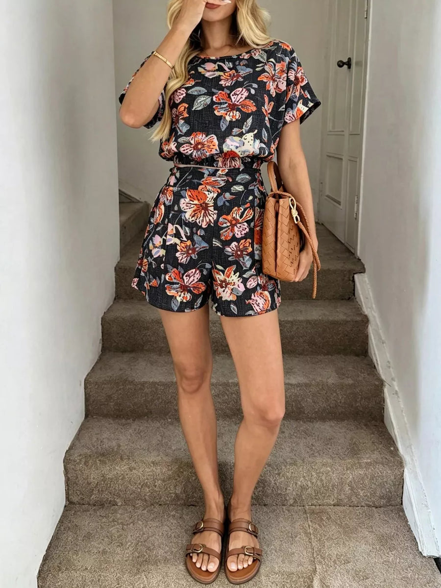 Floral two-piece set in navy blue with a crop top and shorts, featuring short sleeves and a round neckline.