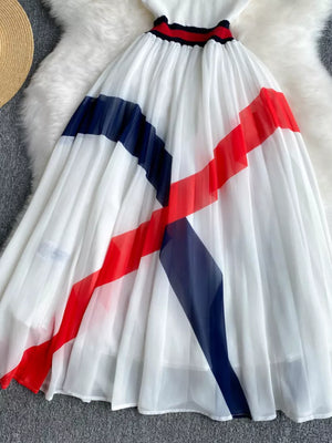 White pleated midi dress with red and blue color block stripes and trim.