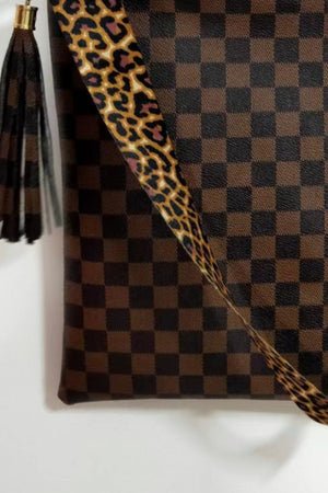 Chocolate crossbody bag with checkerboard pattern, leopard print strap, and tassel detail.