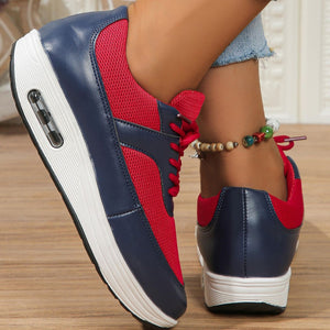 Red and navy breathable lace-up wedge sneakers with mesh panels and air cushioning.