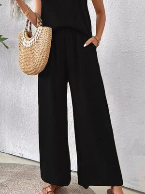 Black wide-leg polyester pants with pockets, part of a two-piece ensemble.