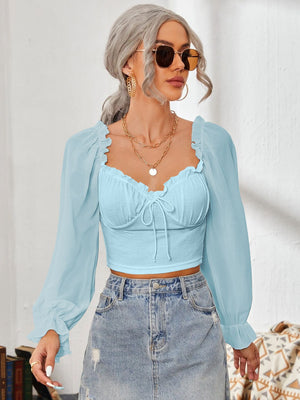 Pastel blue bustier blouse with tie front and sheer puff sleeves.