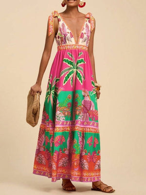 Tropical print maxi dress with tie shoulders, deep V-neck, and tiered skirt in pink and green.