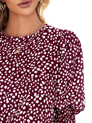 Burgundy animal print blouse with puff sleeves and smocked cuffs.