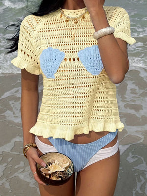 Yellow knit top with seashell cups and ruffled hem, styled with bikini bottoms.