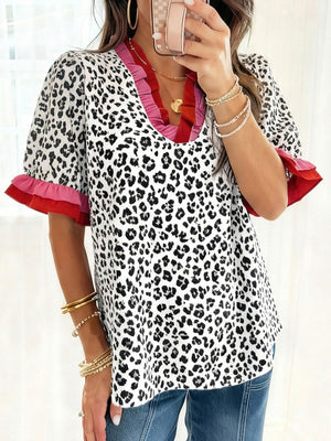 Leopard print blouse with ruffled neckline and sleeves in pink and red.