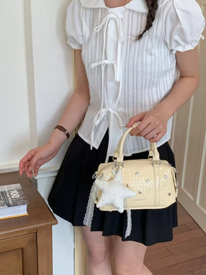 crossbody bag in pale yellow featuring star embellishments and structured fit