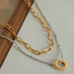 Gold layered necklace with beaded chain and textured ring pendant