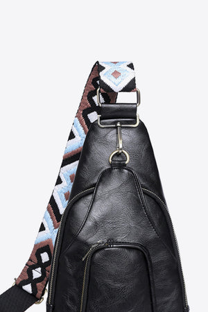 Black PU sling bag with a patterned strap and zippered front pocket.