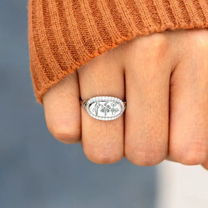 Silver signet ring with engraved floral design and pave crystal border.