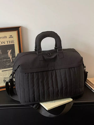 Chic quilted nylon travel bag in black with adjustable strap and padded handles.