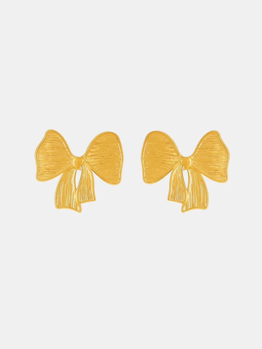 Sculpted bow earrings in 18K gold with textured detail.