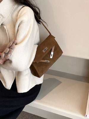 Brown suede shoulder bag with silver buckle detail and tan strap.