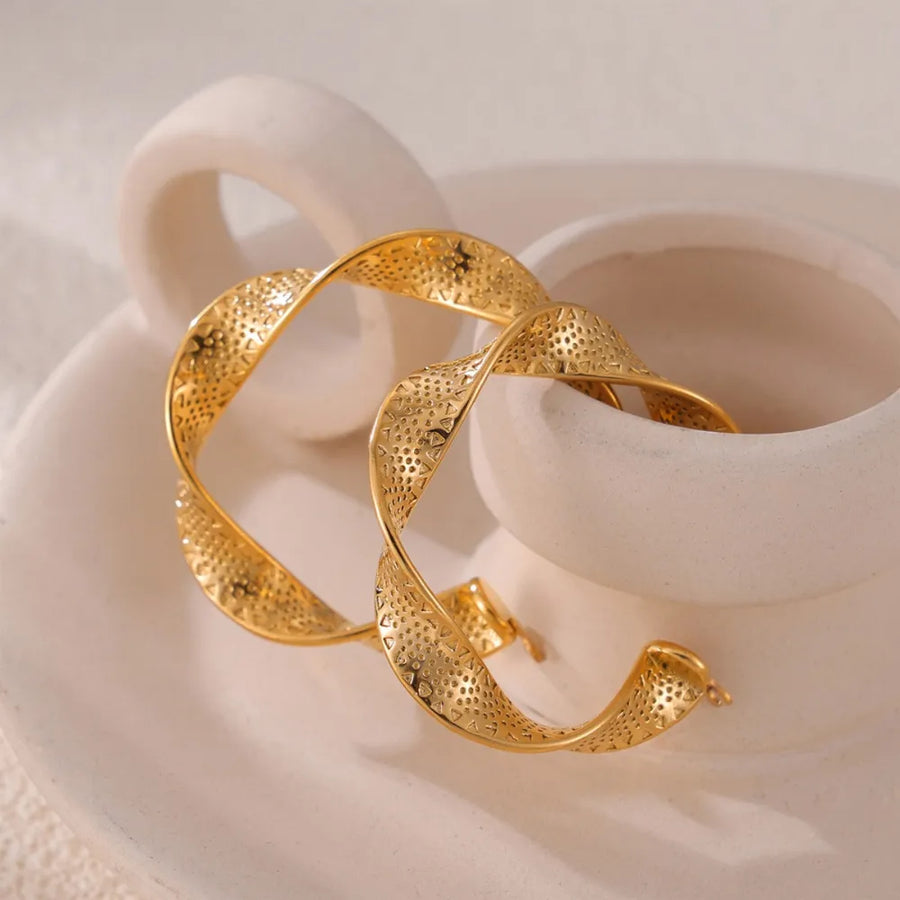 Textured gold hoop earrings with a twisted spiral design and perforated pattern.