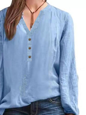 Light blue long-sleeve blouse with notched neckline and button detail