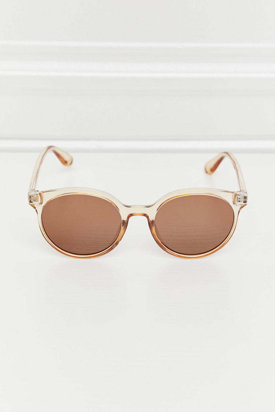 Tortoiseshell round frame sunglasses with tan translucent frames and brown lenses.