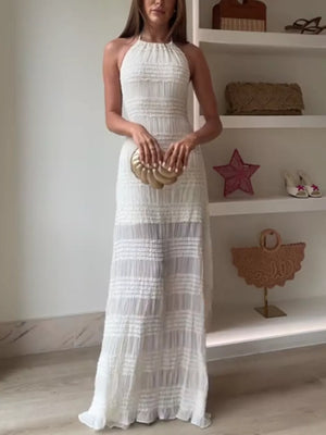 Textured halter neck maxi gown in white with tiered fabric and a flowing skirt.