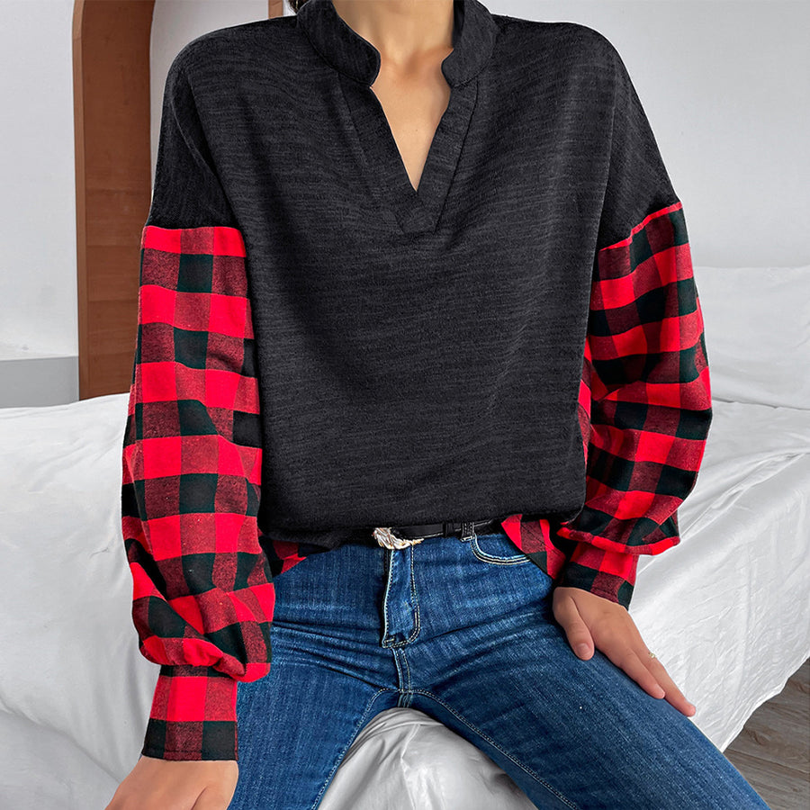 Black henley top with contrast red buffalo plaid balloon sleeves and V-neck.