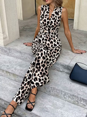 Sleeveless leopard print romper with V-neck and cinched waist, styled with black sandals.