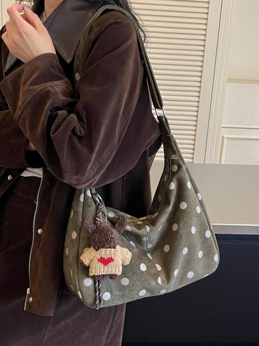 Green handbag featuring zipper closure and polka dot